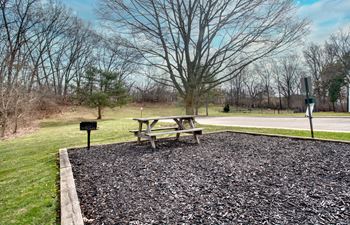 A picnic table sits in the middle of a gravel area.